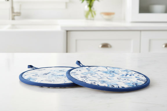 Two blue and white patterned pot holders on a white kitchen counter.